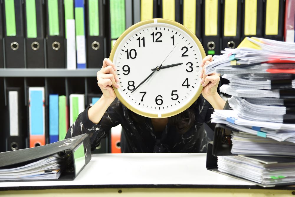 office worker holding a clock working overtime an 2022 11 09 14 57 47 utc copy