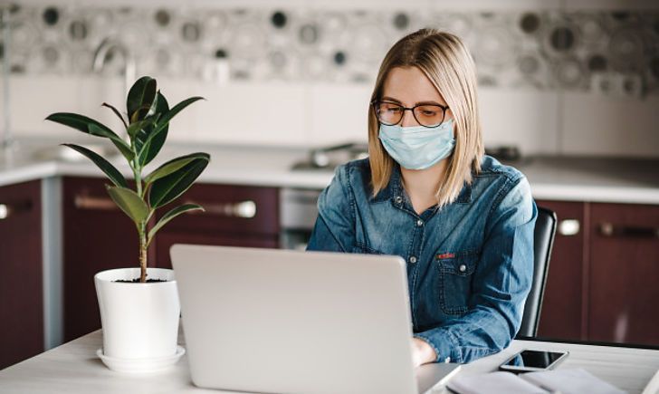 coronavirusbusinesswomanworkinghomewearingprotectivemaskquarantine18073155 2e9b14aa30e0624412cb429a40eedbdf