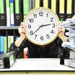 office worker holding a clock working overtime an 2022 11 09 14 57 47 utc copy